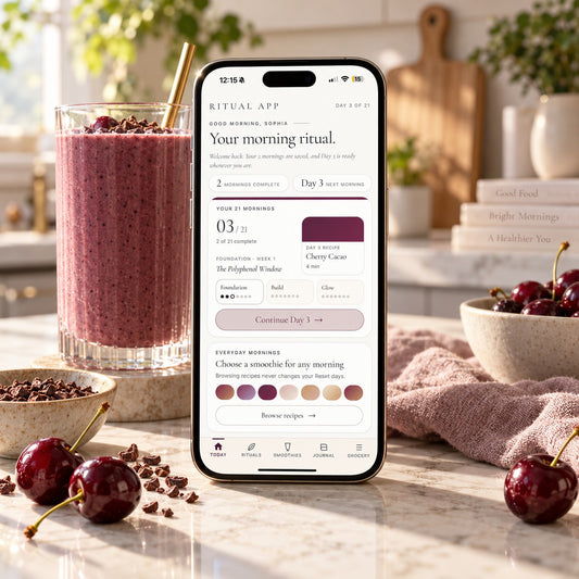 Ritual app on a phone beside a berry smoothie in a sunlit kitchen